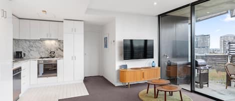 Een modern appartement met keuken, woonruimte en balkon met uitzicht op de stad.