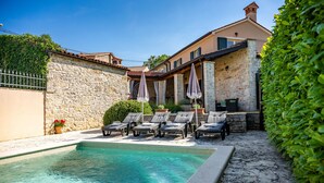 A pool area with lounge chairs and umbrellas, stone walls, and a well-maintained garden. - Awesome home in Labin - Rabac (Labin - Rabac)