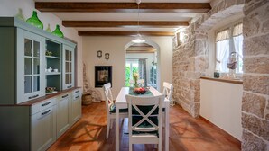 A kitchen with a dining area, stone walls, and a fireplace. - Awesome home in Labin - Rabac (Labin - Rabac)
