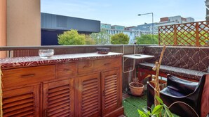 Ein Balkon mit Holzbalken, Sitzgelegenheiten und einem Blumentopf.