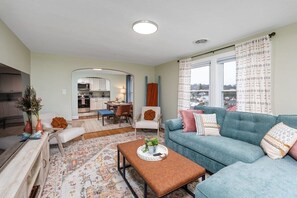 Ein modernes Wohnzimmer mit Sofa, Couchtisch und Essbereich.