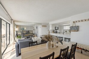 A modern kitchen with white cabinets, a microwave, and a hanging rack. - Luxury Oceanfront Getaway on the Top Floor Penthouse Corner Unit Steps from the Beach (Cocoa Beach)