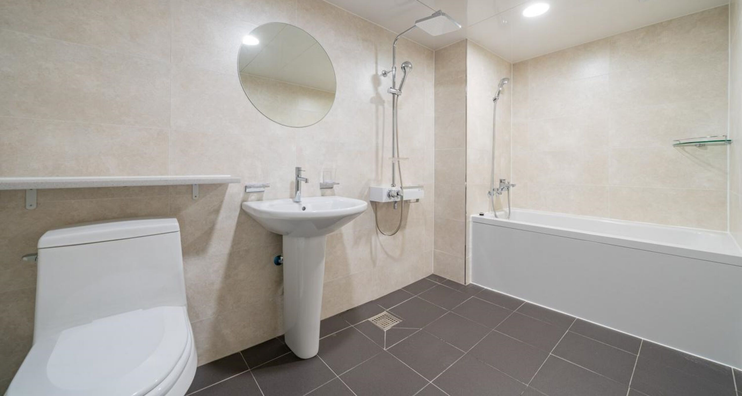 A modern bathroom with a toilet, sink, and bathtub.
