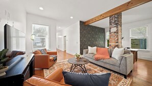 Un salon moderne avec un canapé, une table basse et une cheminée.