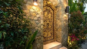 Stunning entrance with ornate door and lush greenery.