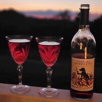 Dos copas de vino tinto y una botella de vino de mesa Chateau Morriette Red Mountain Laurel.