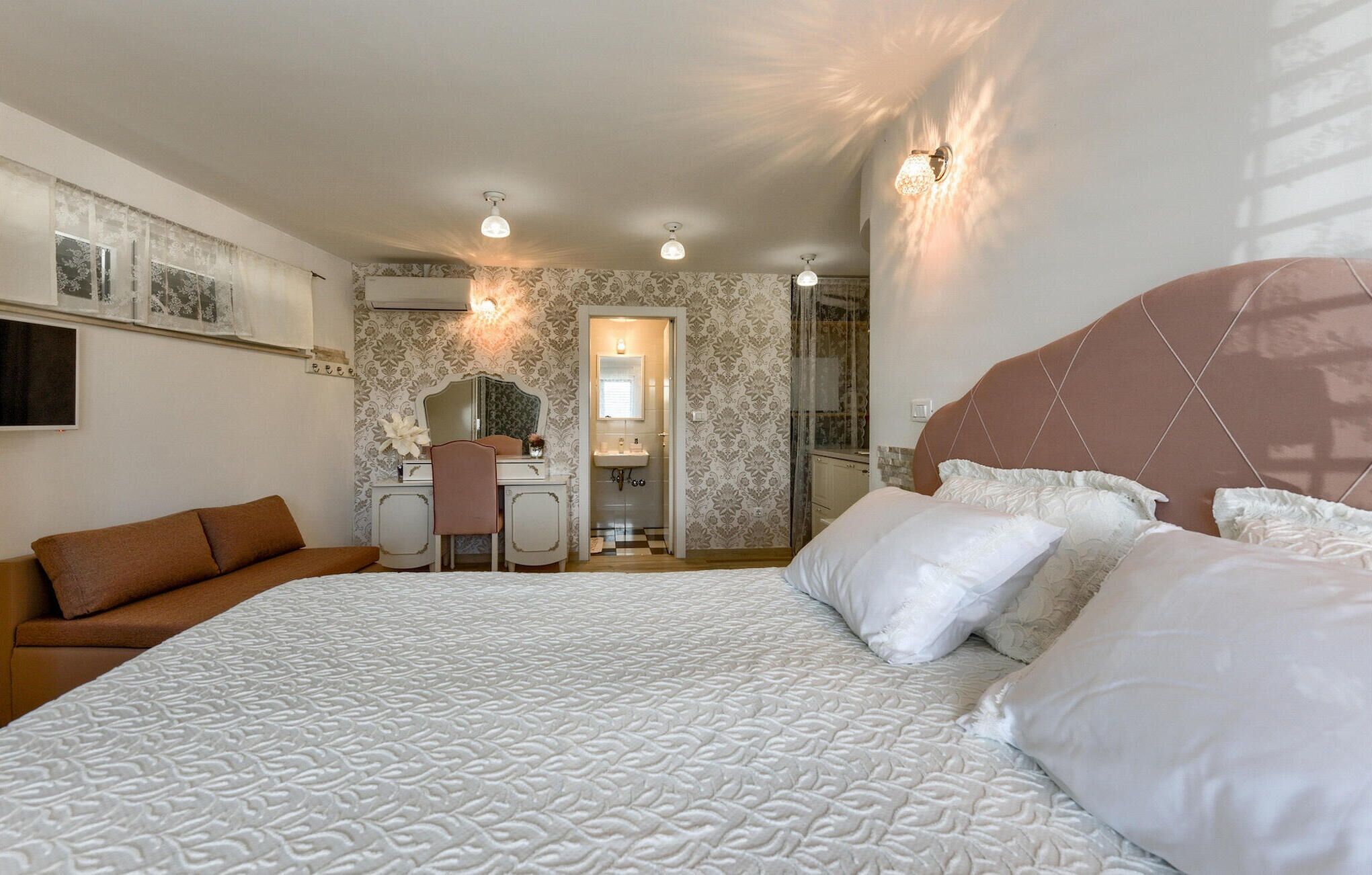 Un dormitorio con una cama grande, un escritorio y una silla.