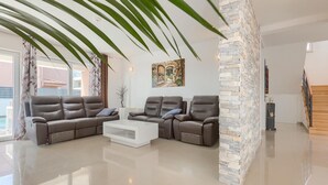 Un salon moderne avec un canapé d’angle, une table basse et un mur décoratif en pierre.