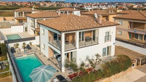 Un immeuble résidentiel à plusieurs étages doté d’une piscine sur le toit, d’un espace extérieur aménagé et offrant une vue sur le quartier environnant.