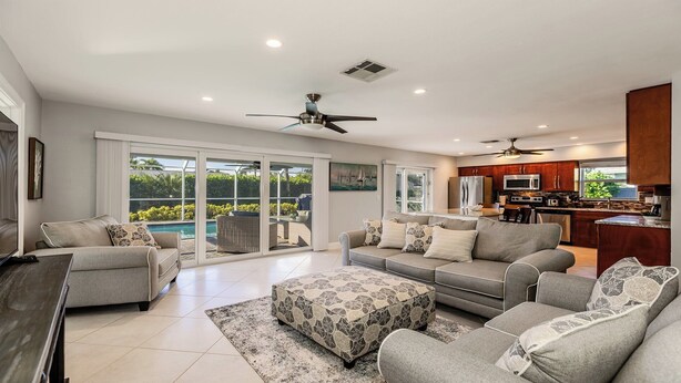 A spacious living area with a large sofa set, a dining table, and a kitchen area with modern appliances. - Impeccably maintained Marco Island oasis! (Marco Island)