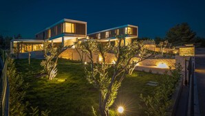 A modern two-story house with a flat roof and large windows, surrounded by a well-maintained garden. - Nice home in Primosten (Primosten)