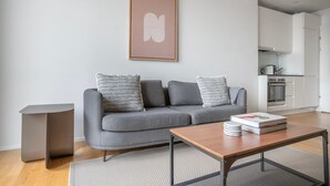 A modern living room with a grey sofa, a coffee table, and a framed artwork on the wall. - Chic Horgen 2BR w/ Storage Room & Lake View, nr Market, by Blueground (Zurich)