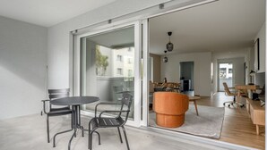 En modern lägenhet med balkong, matplats och kök.