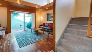 A spacious living area with a sofa, a coffee table, and a staircase. - Discounted Rates - Ocean Beach Holiday (San Diego)