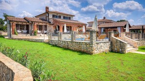 A two-story house with a stone facade, a swimming pool, and a well-maintained lawn. - Beautiful home in Porec (Porec)