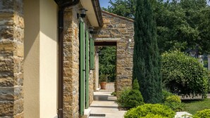 A stone building with a covered walkway and a basketball court in the background. - Amazing home in Motovun (Motovun)