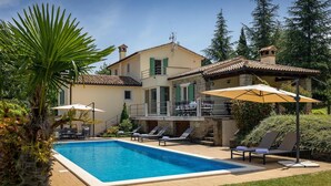 A two-story house with a swimming pool, outdoor seating, and a garden. - Amazing home in Motovun (Motovun)