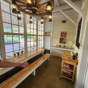 Una habitación acogedora con bancos de madera, techo rústico y vistas al exterior a través de amplios ventanales.