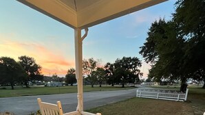 A wooden porch with two rocking chairs and a white fence. - Take a trip back in time and stay at the Larissa House Inn! (Jacksonville)