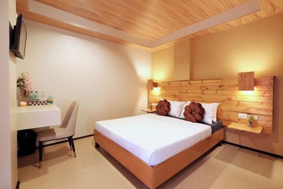 A bedroom with a wooden bed, a desk, and a chair.