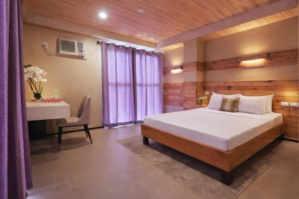 A bedroom with a wooden bed, a desk, and a chair.