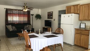 A dining area with a table set for four, surrounded by wooden chairs. A ceiling fan is visible above the table, and a television is mounted on the wall to the left. - Craigmont Getaway
Get comfortable and enjoy plenty of space and cozy fireplace! (Craigmont)