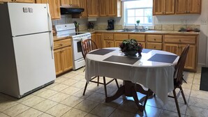 A kitchen with wooden cabinets, a white refrigerator, a stove, and a dining table with chairs. - Craigmont Getaway
Get comfortable and enjoy plenty of space and cozy fireplace! (Craigmont)