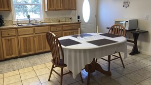 A kitchen with wooden cabinets, a dining table with chairs, a clock, and an air conditioning unit. - Craigmont Getaway
Get comfortable and enjoy plenty of space and cozy fireplace! (Craigmont)