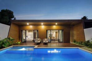 A modern house with a swimming pool, wooden exterior, and a dining area visible through large glass doors.