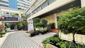 A hotel with a sign for rooms for rent, outdoor seating, and potted plants. - Sawasdee Apartment Patong (Patong)