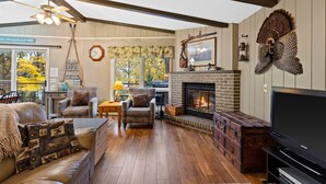 A cozy living room with a fireplace, leather furniture, and a television.