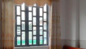 Una habitación con dos camas, una ventana con cortinas y un ventilador de techo.