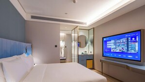 A modern hotel room with a large bed, a television on the wall, and a mirror. - Beijing Tiananmen Qianmen Manxin Hotel (Beijing)
