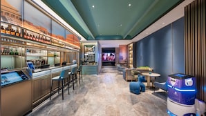 A modern bar area with a digital screen, seating, and a vending machine. - Beijing Tiananmen Qianmen Manxin Hotel (Beijing)