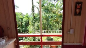 A room with a tiled floor, a red railing outside, and a view of greenery. - Chalé Mirante do Félix Ubatuba  (Ubatuba)