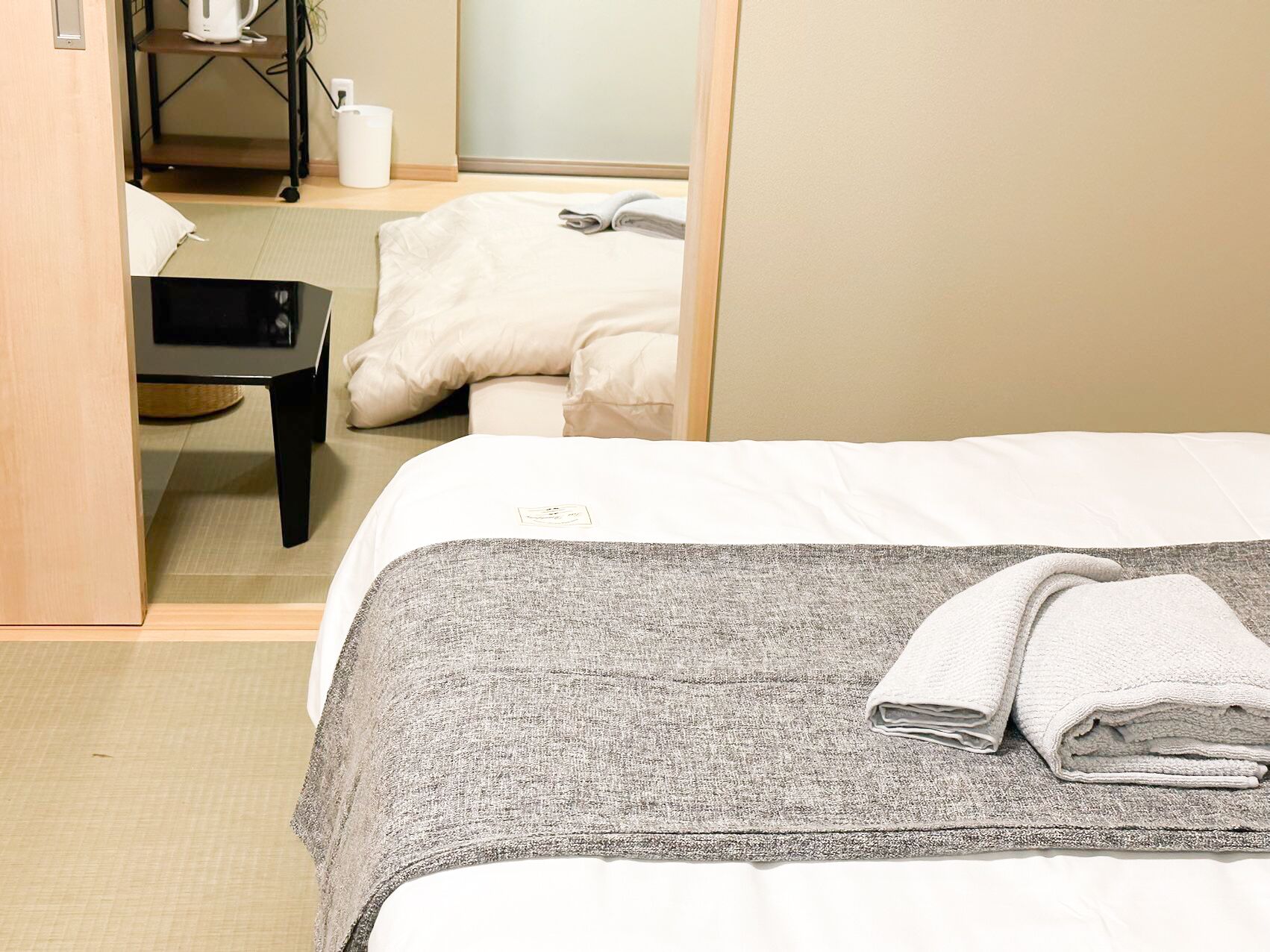 Una habitación de hotel con una cama, un escritorio, una silla y un espejo.