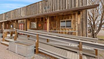 A rustic wooden building with a wooden ramp leading to a covered area.