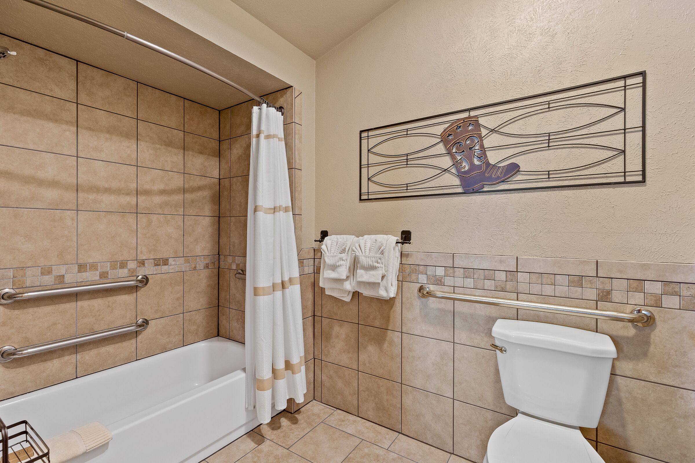 A bathroom with a bathtub, toilet, and shower curtain.