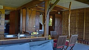 Ein rustikales Holzinterieur mit Küchenzeile, inklusive Spüle und Esstisch mit Stühlen.