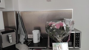 Une petite cuisine équipée d’une machine à café, d’un four à micro-ondes et d’un livre d’édition limitée posé sur le comptoir.