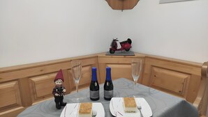 Une table à manger avec des bouteilles de vin, des verres et un gâteau.