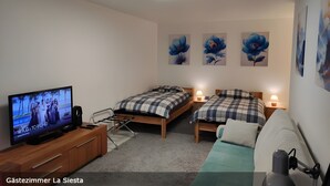 Une chambre d’hôtel avec deux lits, une télévision, un bureau et un canapé.