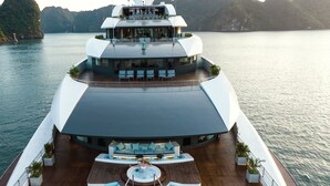 Un moderno crucero con una amplia cubierta, asientos exteriores y un jacuzzi.