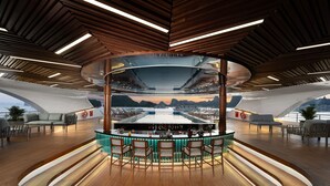 Un área de bar moderna con cerramiento de vidrio curvo, suelo de madera y disposición de asientos.