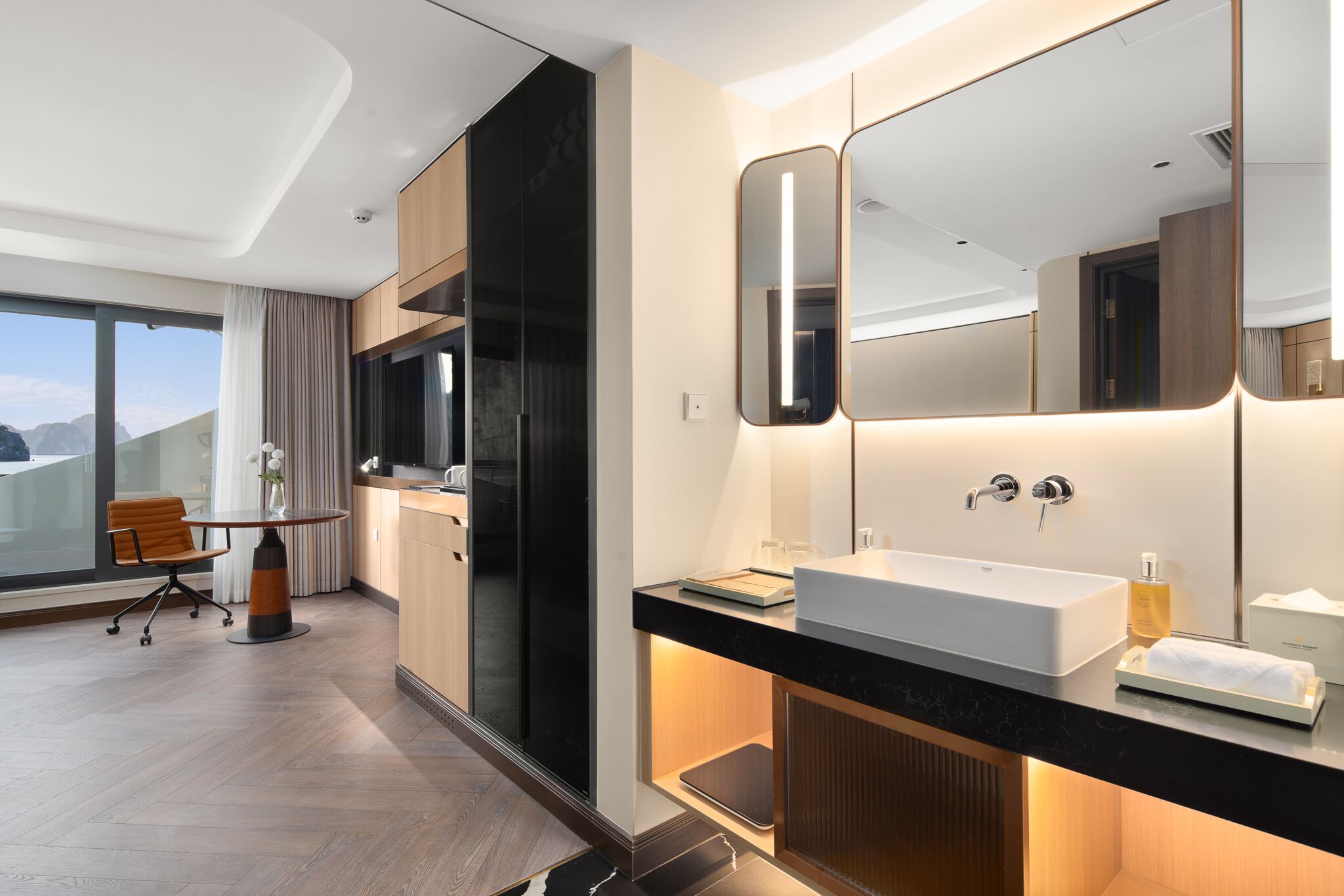 Une salle de bain d’hôtel moderne, dotée d’un grand miroir, d’un lavabo et d’un meuble-lavabo.