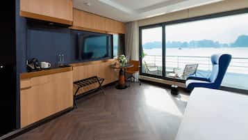 Enjoy a serene view of the water and distant landforms from this stylish room with a flat-screen TV, comfortable seating area, and beautiful vase of flowers.