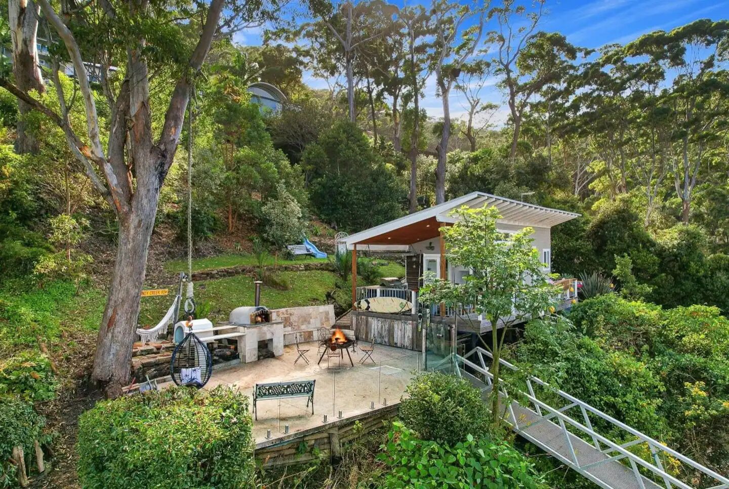A house with a patio area, outdoor seating, and a barbecue grill.