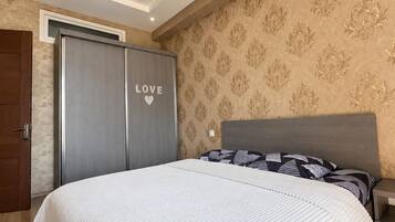 A bedroom with a bed, a wardrobe, and a nightstand.