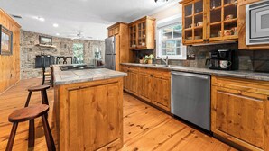 Eine Küche mit Holzausstattung, einem Edelstahlkühlschrank und einem eingebauten Geschirrspüler.