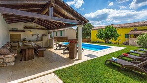A covered outdoor area with a pool, seating, and a dining setup. - Cozy home in Porec with sauna (Porec)